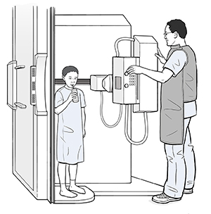 Child standing in flouroscopy scanner sipping a bottle of liquid through a straw while a healthcare provider adjusts the machine.
