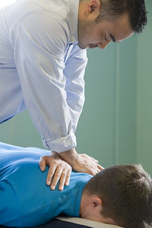 Masseuse giving man a back massage.