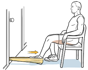 Man sitting on chair with heel in resistance band, doing hamstring curl exercise.