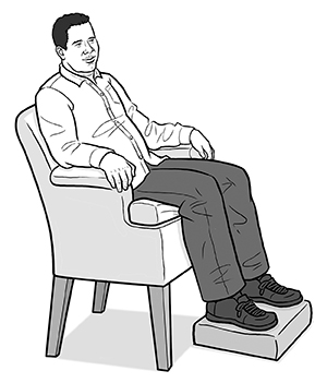 Man sitting in chair with back straight and feet on footrest.