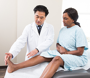 Healthcare provider examining woman's foot.