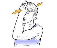 Woman holding hand to forehead doing neck isometric exercise.
