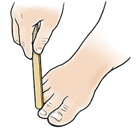 Mano con lima para uñas limando un callo en un dedo del pie.