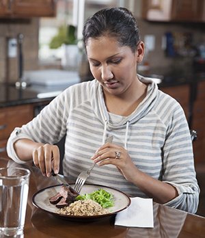 Una mujer comiendo alimentos saludables.