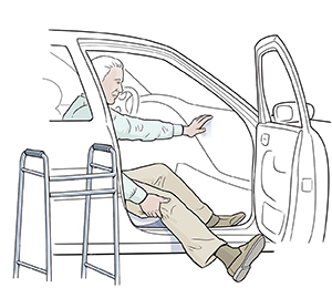 Hombre sentado en el lado del acompañante de un automóvil introduciendo la pierna derecha con cuidado. Hay un andador junto al automóvil.