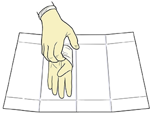 Mano enguantada que toma un guante estéril de un paquete de guantes estériles abierto empleando dos dedos para tomar el guante por debajo del puño.