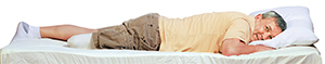 Hombre con la pierna amputada, acostado boca abajo con la cabeza apoyada en una almohada.