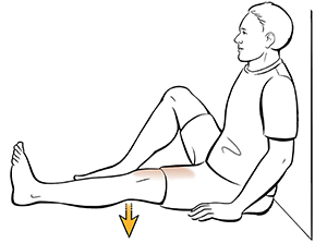 Un hombre sentado haciendo ejercicios de cuádriceps.