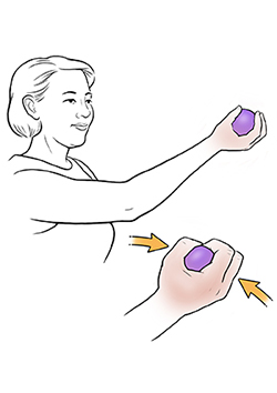 Mujer haciendo un ejercicio que consiste en apretar una pelota.