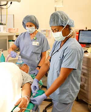 Proveedores de atención médica en el quirófano preparando a un hombre para una cirugía.
