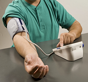 Hombre midiéndose la presión arterial en su hogar. 