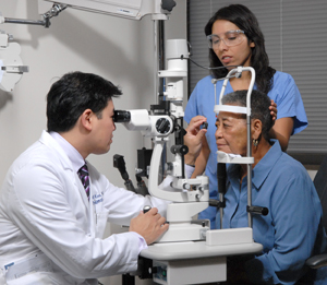 Ophthalmologist and assistant treating woman's eyes.