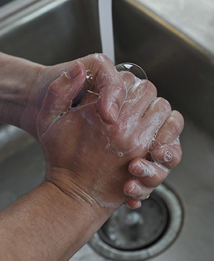 Primer plano de manos que se lavan en un lavabo.