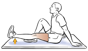 Hombre sentado en el suelo haciendo levantamientos de pierna.