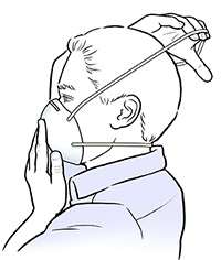 Hombre que coloca la correa superior del barbijo antipolvo sobre su cabeza.