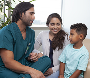 Un proveedor de atención médica habla con una mujer y un niño.